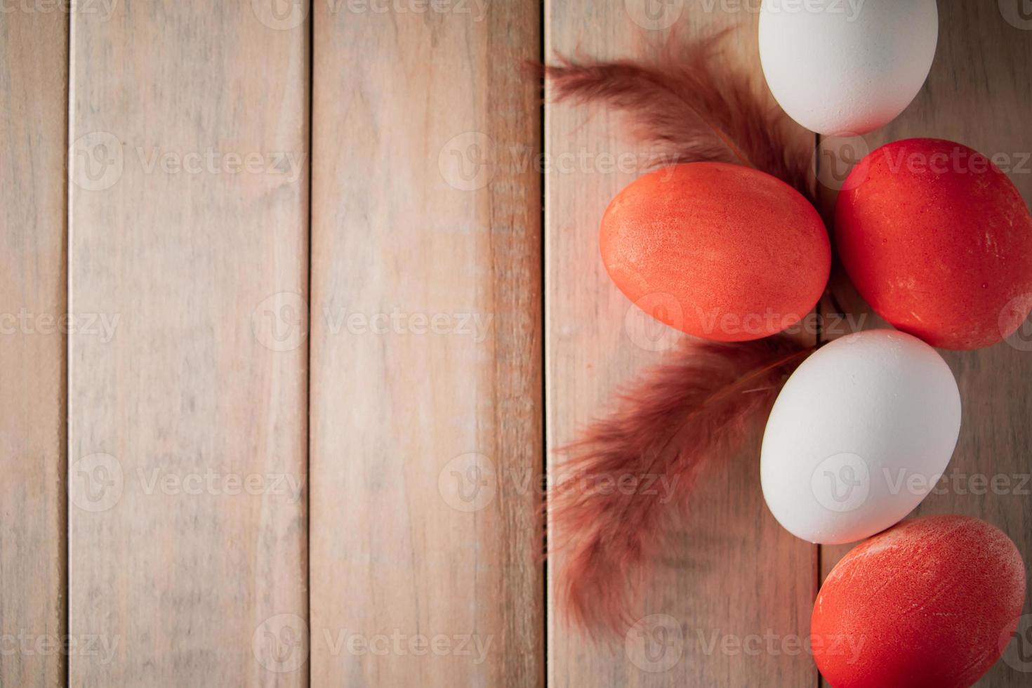 ovos de páscoa brancos e laranja em um fundo claro de madeira foto