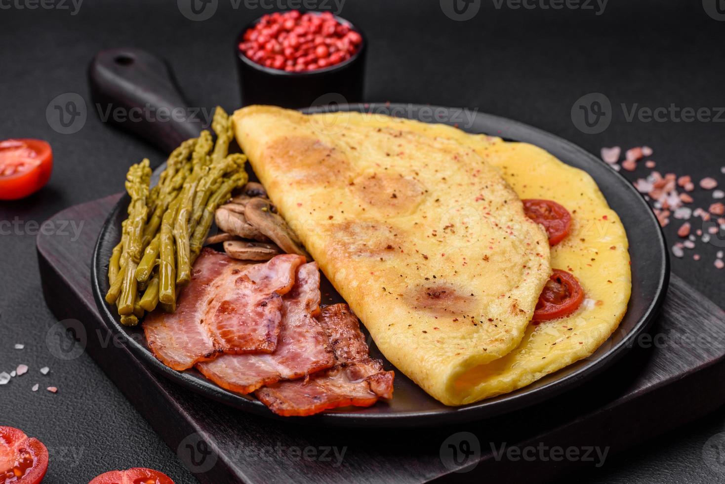 delicioso fresco omelete com cereja tomates, bacon, espargos e especiarias foto