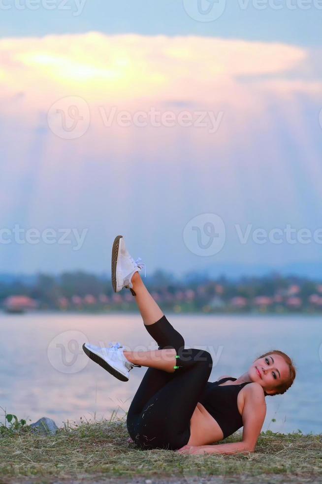 jovem menina fazendo ioga ginástica exercício manhã nascer do sol ao ar livre dentro a Prado lindo montanhas panorama. meditação e relaxar. foto