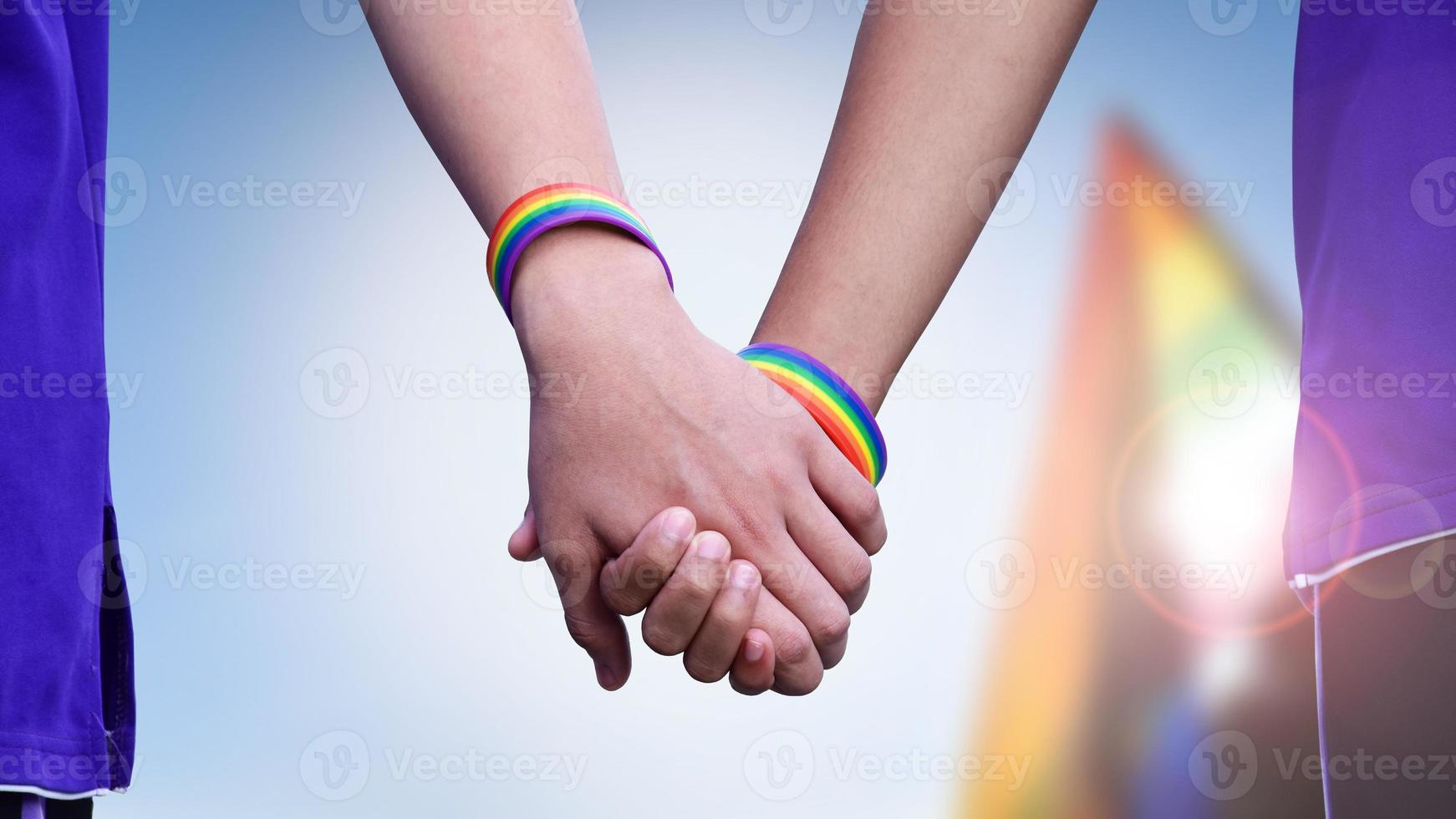 humano mãos que vestem arco Iris pulseira por aí eles, conceito para lgbt pessoas celebração dentro orgulho mês, junho, por aí a mundo. foto