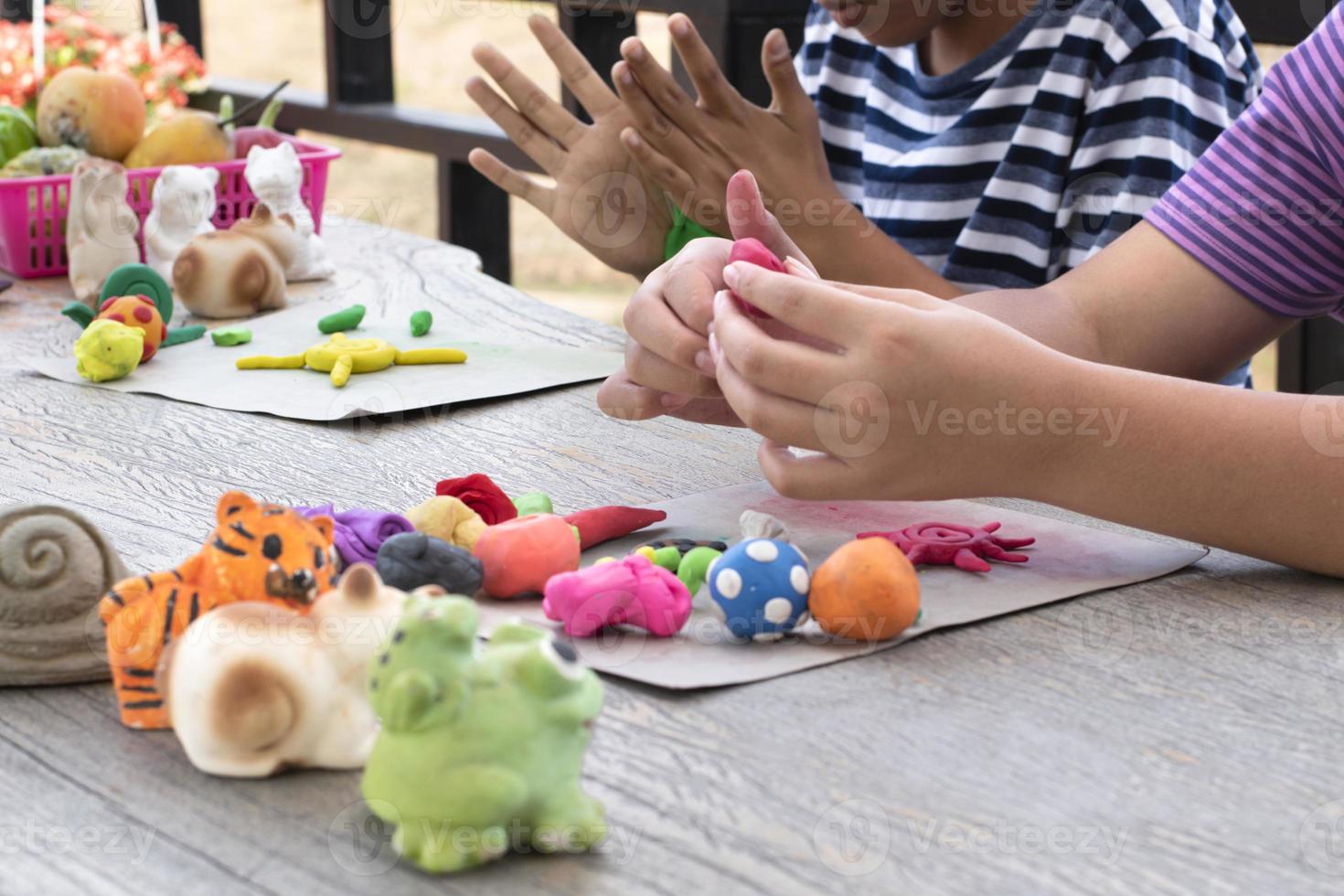 a autista Garoto moldagem diferente formas do colori plasticina preparado de pais às casa dentro ordem para desenvolve vários aspectos dentro seus filho que tem Mais devagar cérebro desenvolvimento que normal crianças. foto