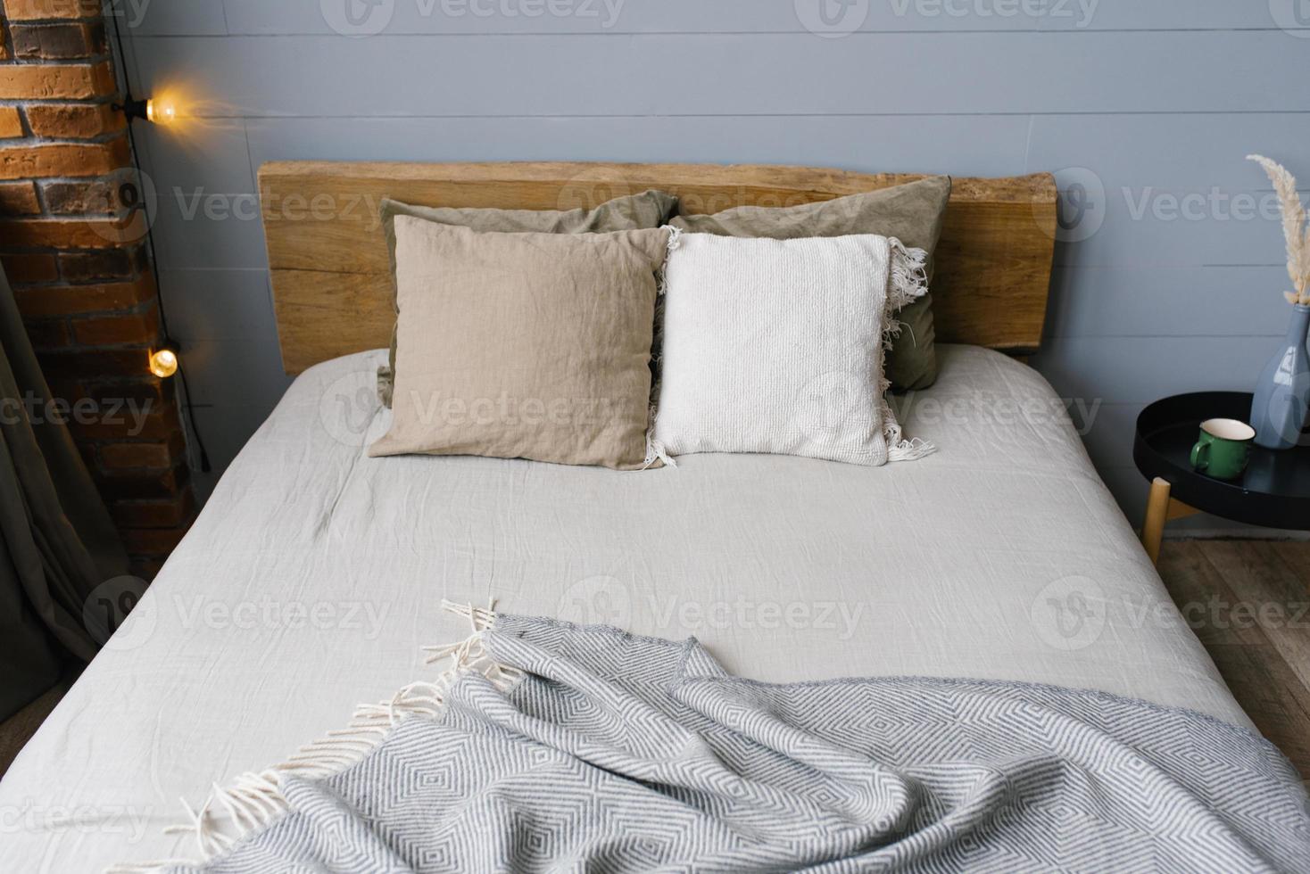 uma moderno escandinavo cinzento quarto com de cor pastel roupa de cama e travesseiros. de madeira cama foto