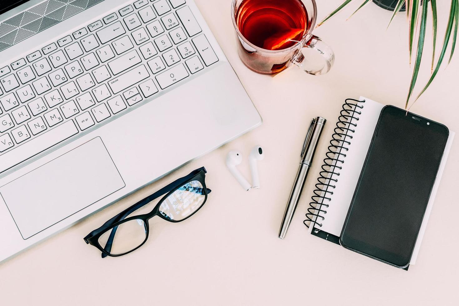 composição de negócios com laptop, óculos, caneta-tinteiro e notebook em uma mesa de trabalho. foto