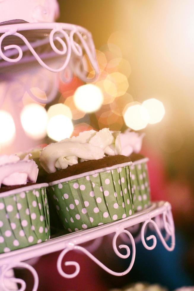 Casamento bolos de copo com colorida granulados dentro verde copo com festão luzes bokeh fundo foto