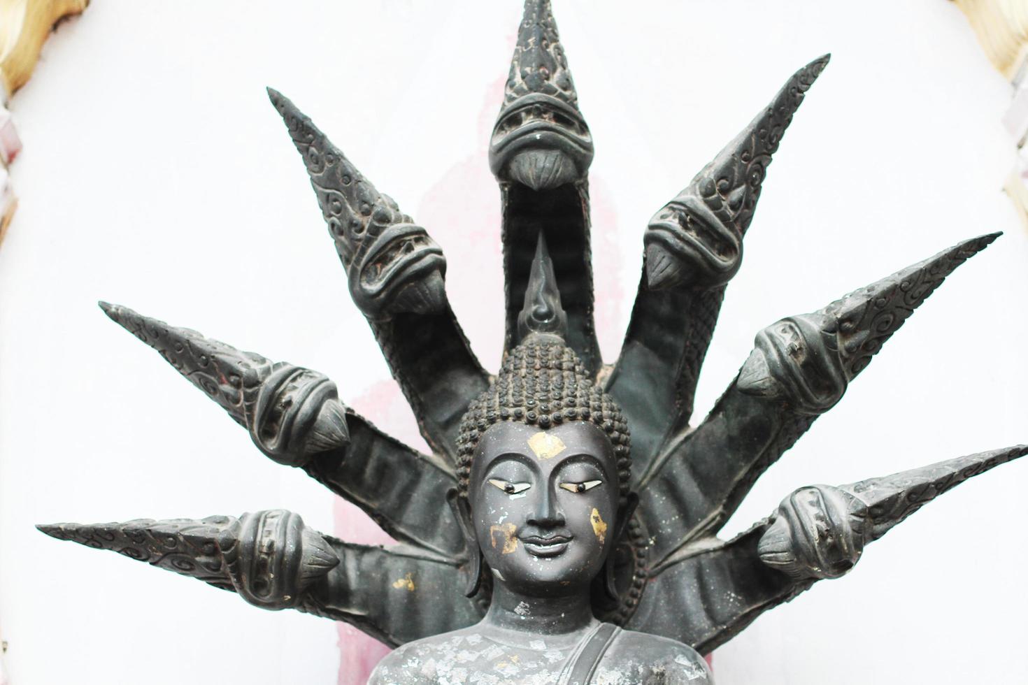 fechadas acima velho prata Buda estátua com uma naga sobre dele cabeça dentro budismo foto