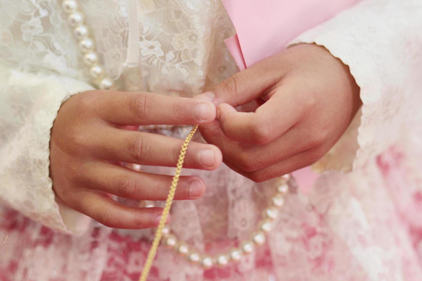 mulher mão segurando ouro colar dentro tailandês noivado cerimónia.tailandês Casamento cultura tradição. foto