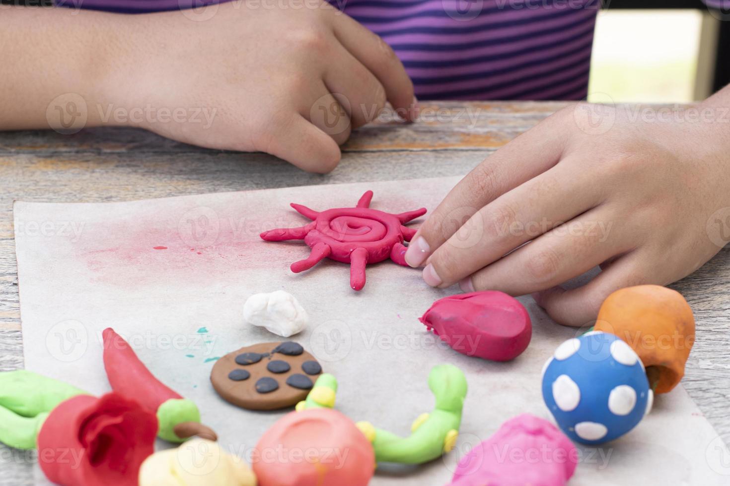 a autista Garoto moldagem diferente formas do colori plasticina preparado de pais às casa dentro ordem para desenvolve vários aspectos dentro seus filho que tem Mais devagar cérebro desenvolvimento que normal crianças. foto