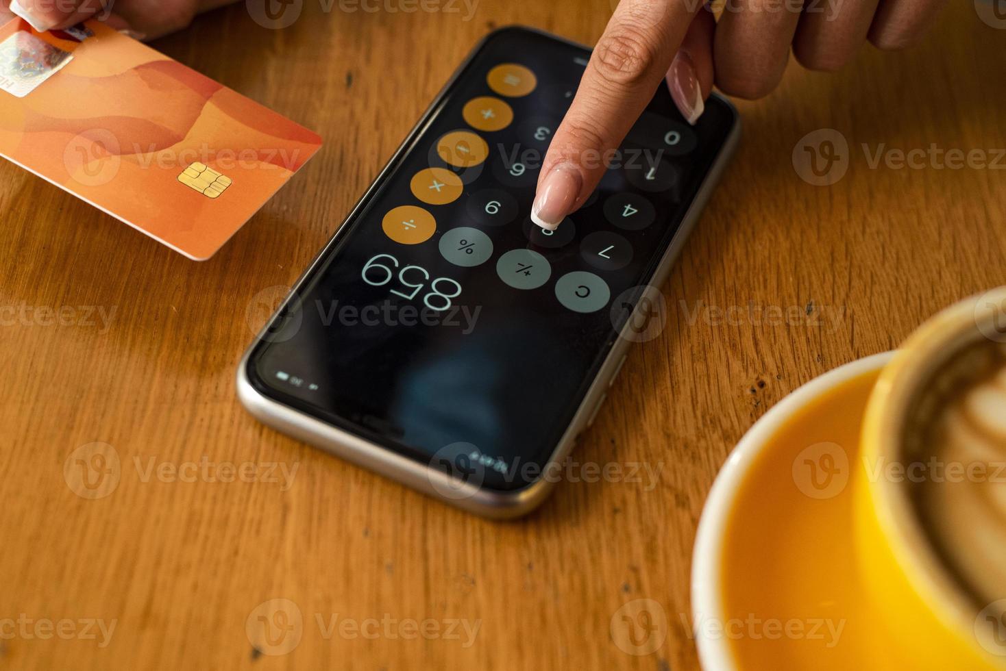 mulher pagando e fazendo compras usando cartão de crédito e calculadora móvel para smartphone foto