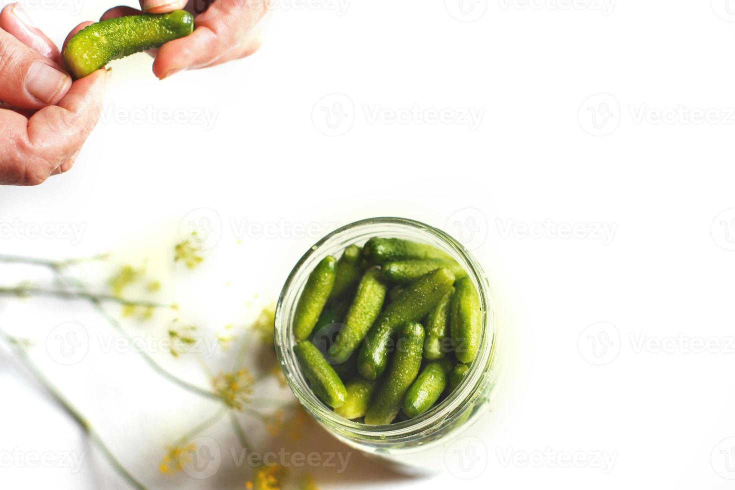 em conserva pepinos dentro uma vidro jar. pepinos pepinos. mulher picles pepinos em uma branco fundo foto