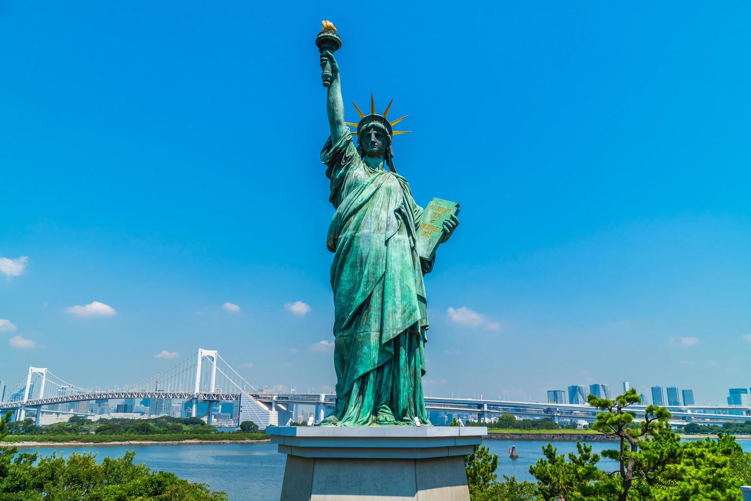 estátua da liberdade com a ponte do arco-íris na ilha de odaiba, tokyo, japão foto