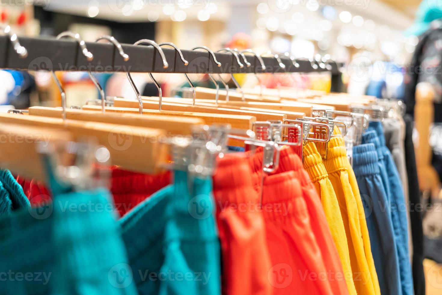 seletivo foco, moda , roupas conceito ,roupas ou calça muitos cores aguentar em uma estante dentro uma desenhador roupas loja. roupas suspensão em uma roupas prateleira dentro uma loja. foto