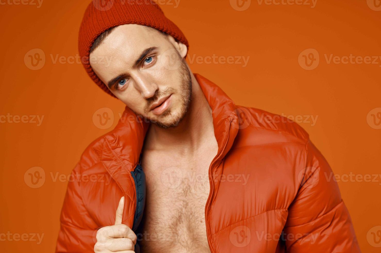 elegante homem dentro vermelho Jaqueta nu corpo estúdio laranja fundo foto