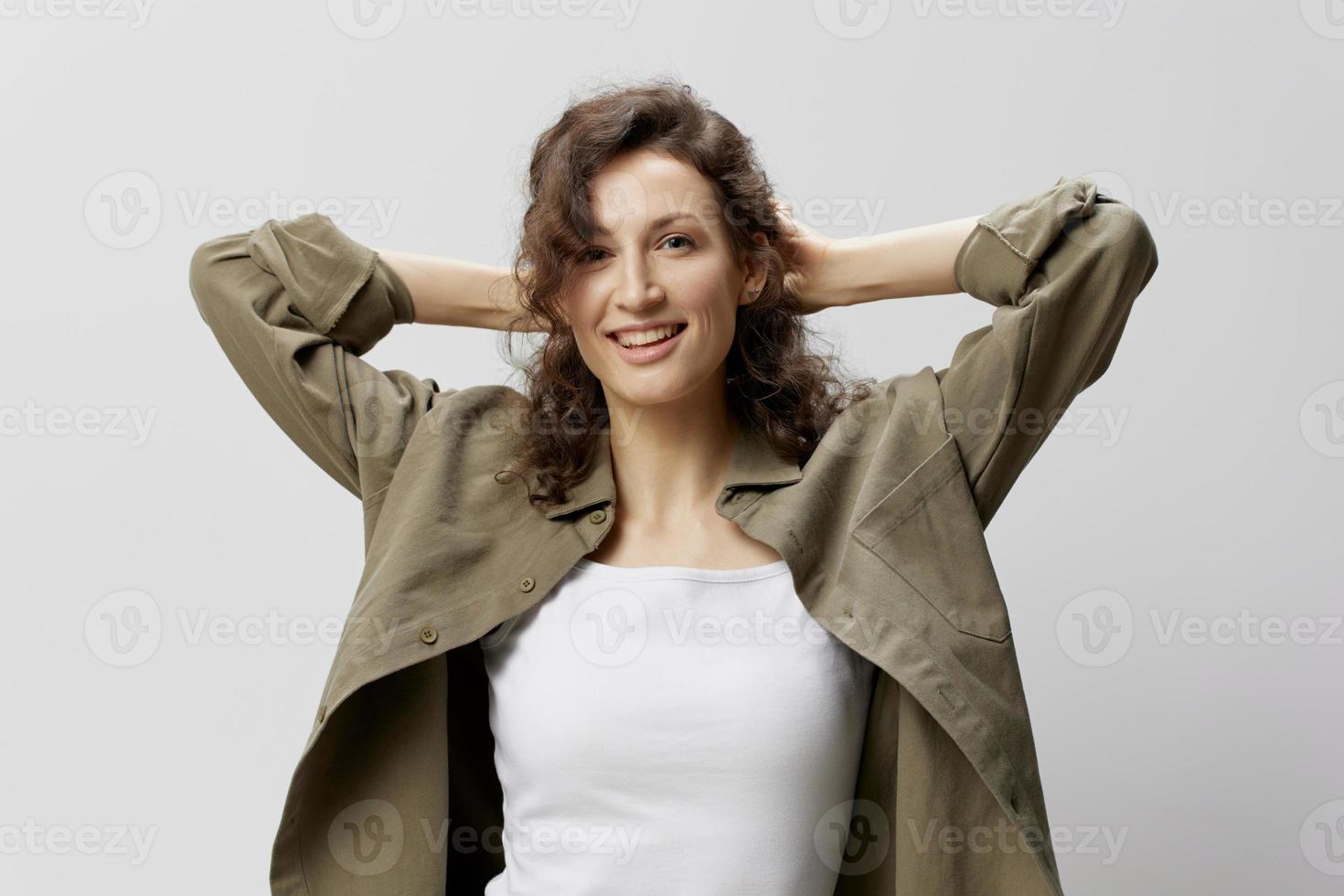 alegre sorridente feliz encaracolado lindo mulher dentro casual cáqui verde camisa toques cabelo parece a parte, de lado posando isolado em sobre branco fundo. pessoas emoções estilo de vida conceito. cópia de espaço foto