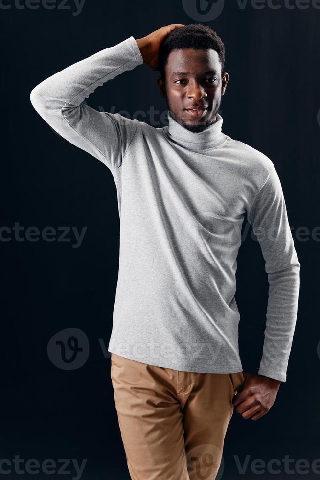 homem do africano aparência dentro cinzento suéter segurando dele cabeça isolado fundo foto