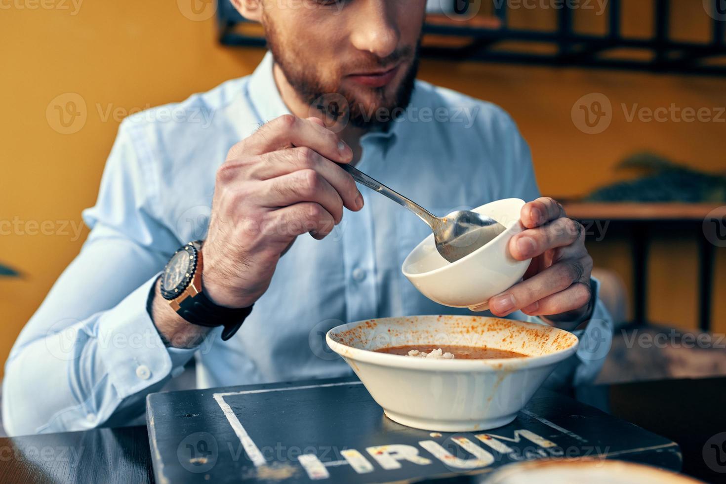 homem comendo borscht e Arroz a grega cafeteria restaurante interior o negócio finança camisa modelo foto