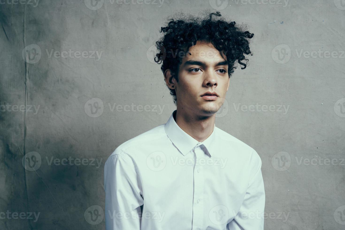 homem dentro branco camisa encaracolado cabelo emoções estúdio moderno estilo foto