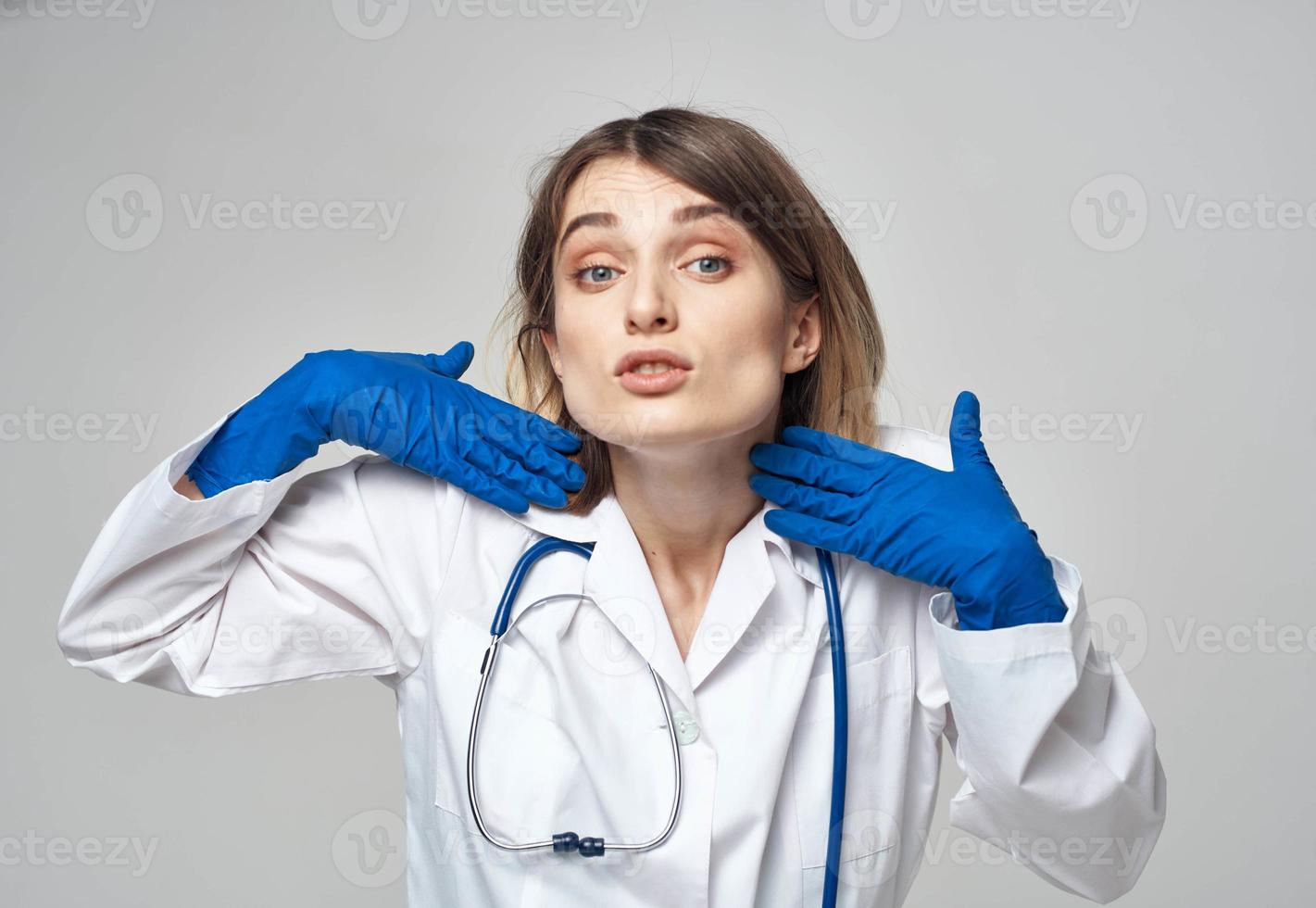 emocional mulher dentro azul médico luvas toques dela cabeça com dela mãos foto