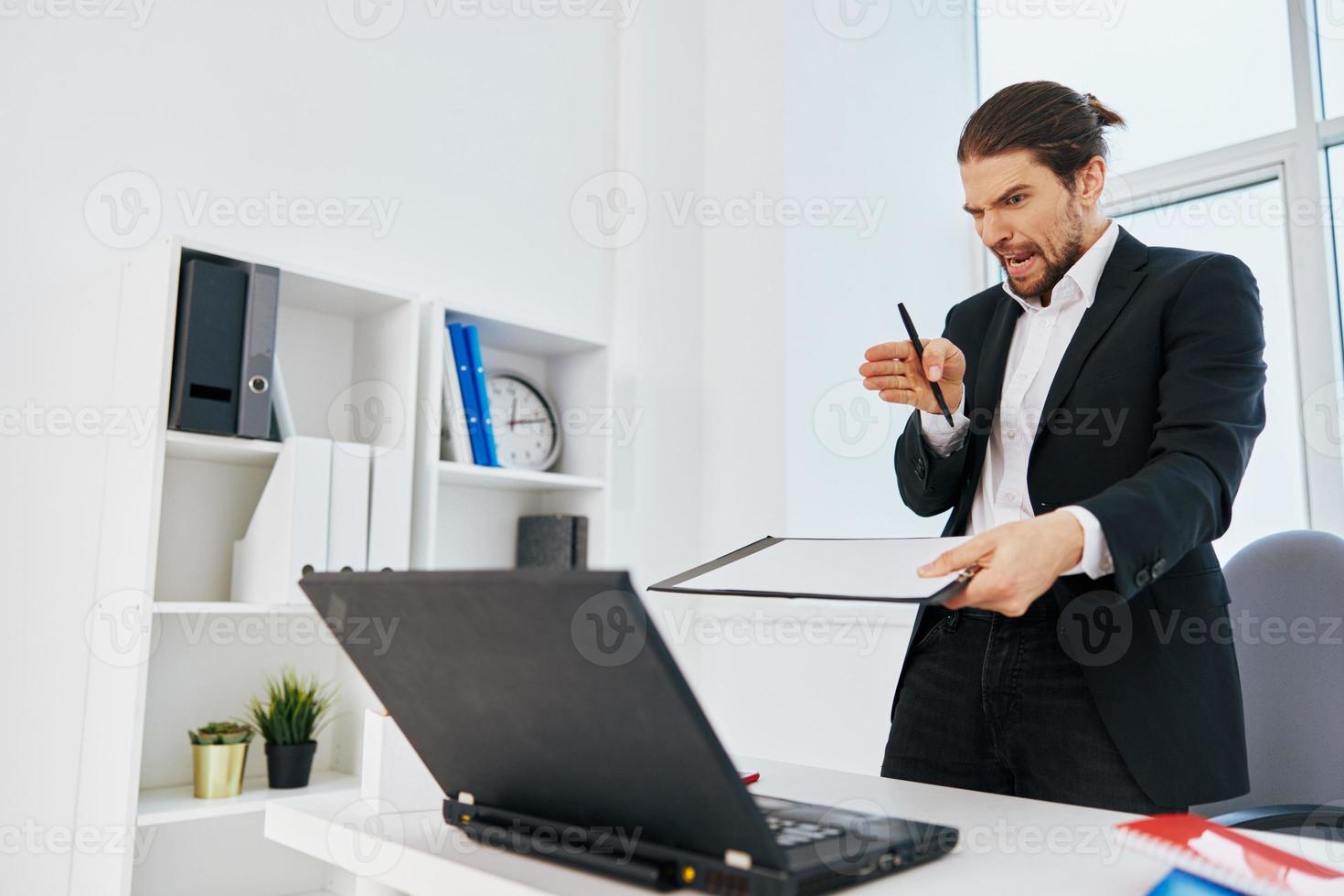 homem trabalhos emoções dentro frente do computador portátil patrão foto