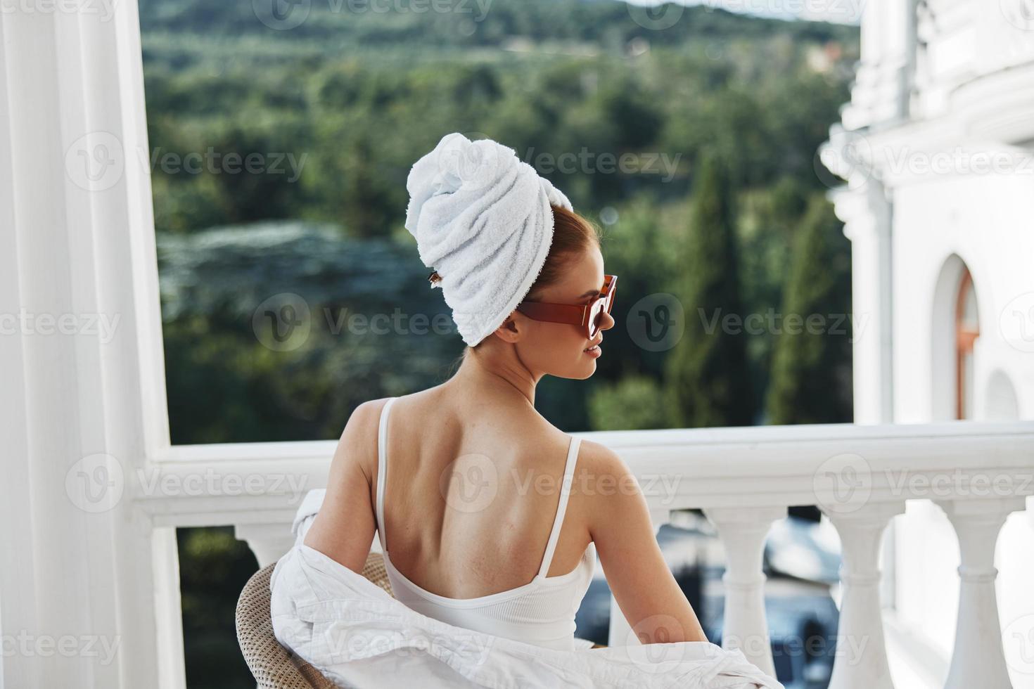 elegante mulher desfrutando às hotel terraço em ensolarado dia inalterado foto