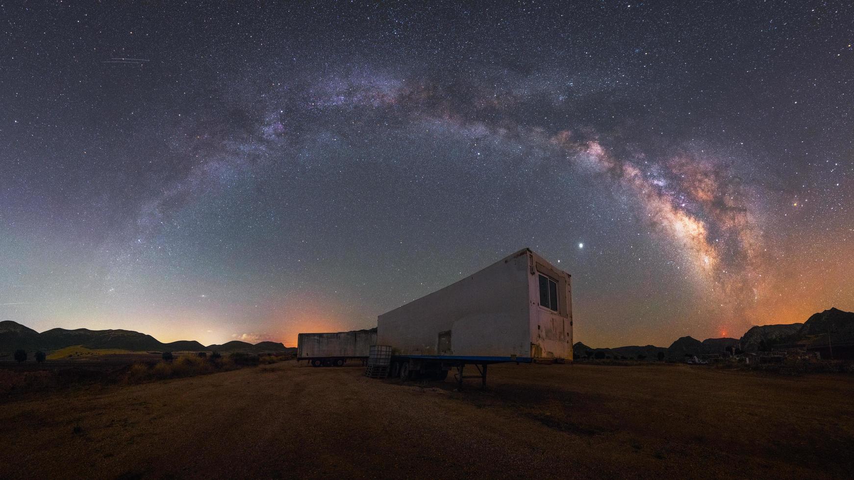 arco da Via Láctea sobre caminhão no deserto foto