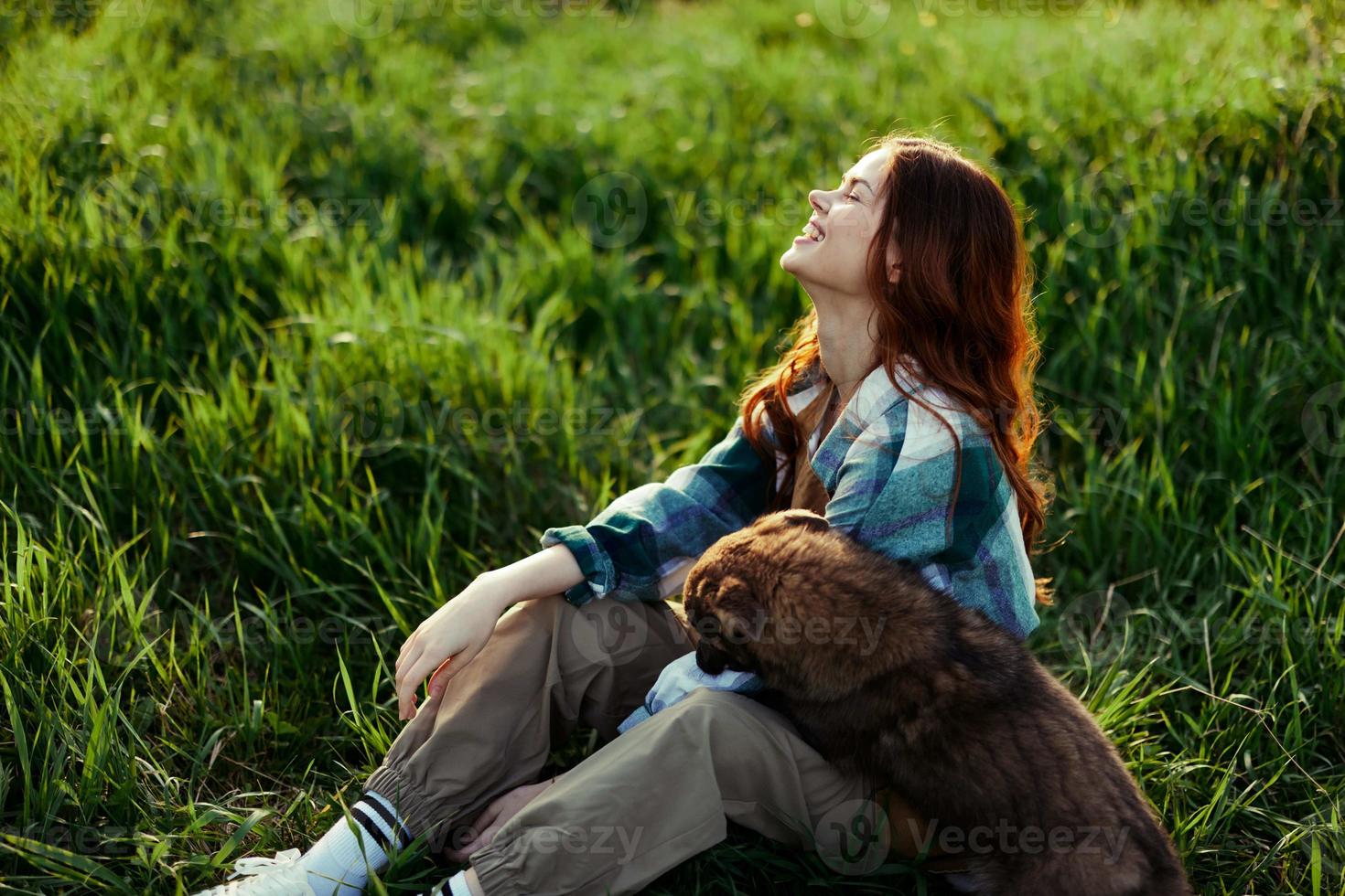 mulher deitado em a Relva sorridente jogando e abraço dela cachorro dentro natureza dentro a parque dentro a verão pôr do sol. a conceito do saúde e amor do animais, tratamento do carrapatos e pulgas Relva e animais foto