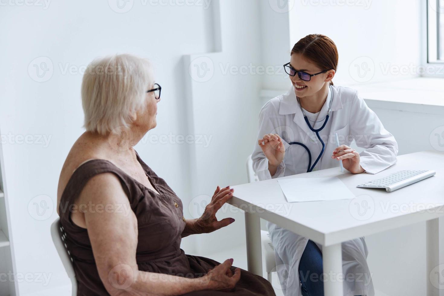 velho mulher paciente comunica com a médico médico escritório foto