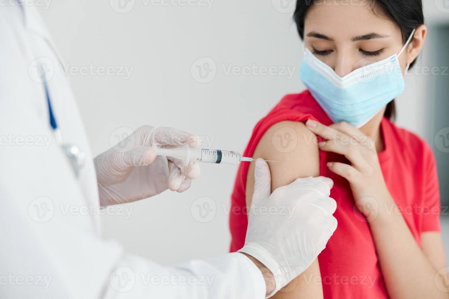 médicos dentro a hospital dando uma tiro para a pacientes ombro cobiçado vacinação foto