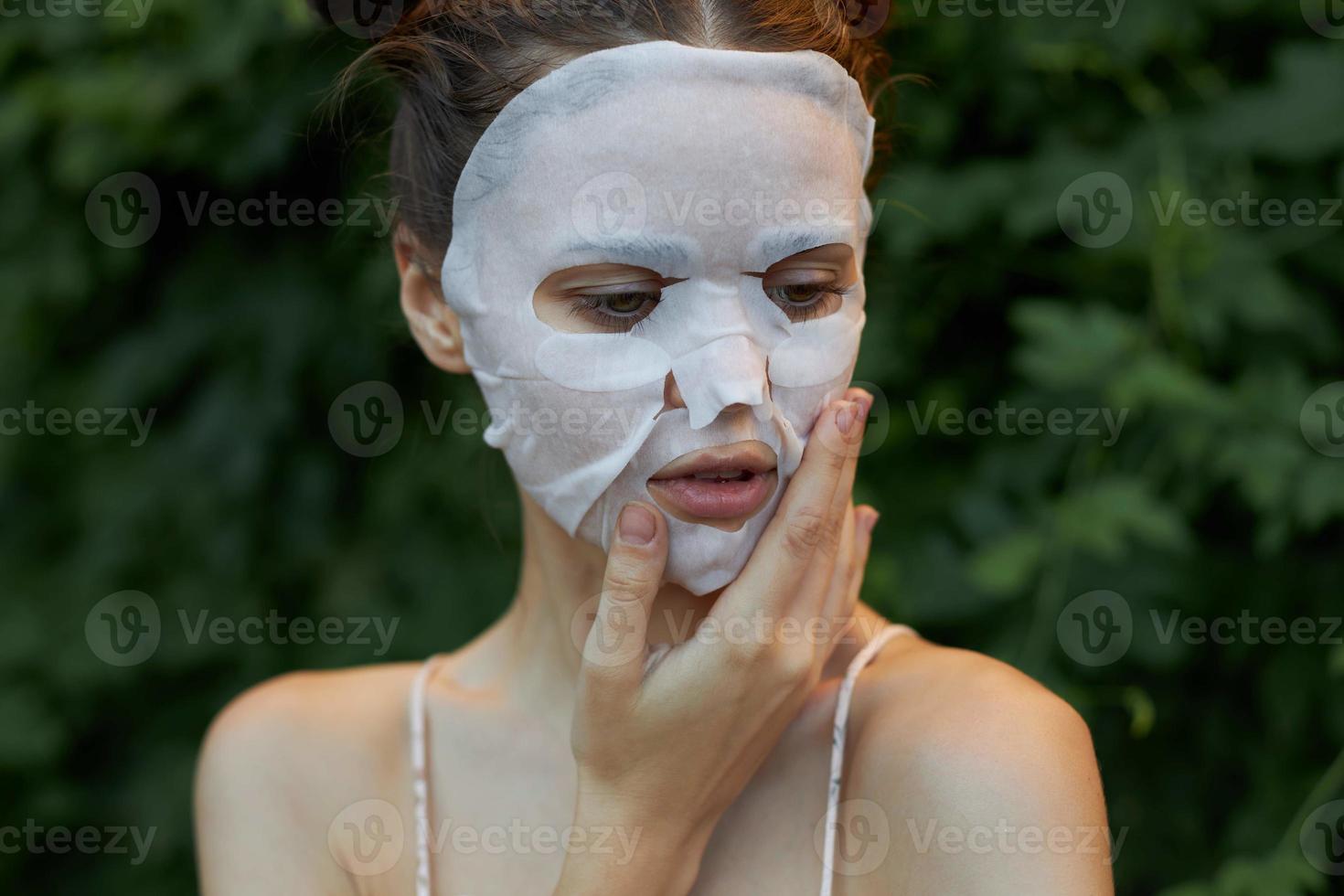 lindo mulher anti-envelhecimento mascarar toque seu face com seu mão dentro natureza nu ombros foto