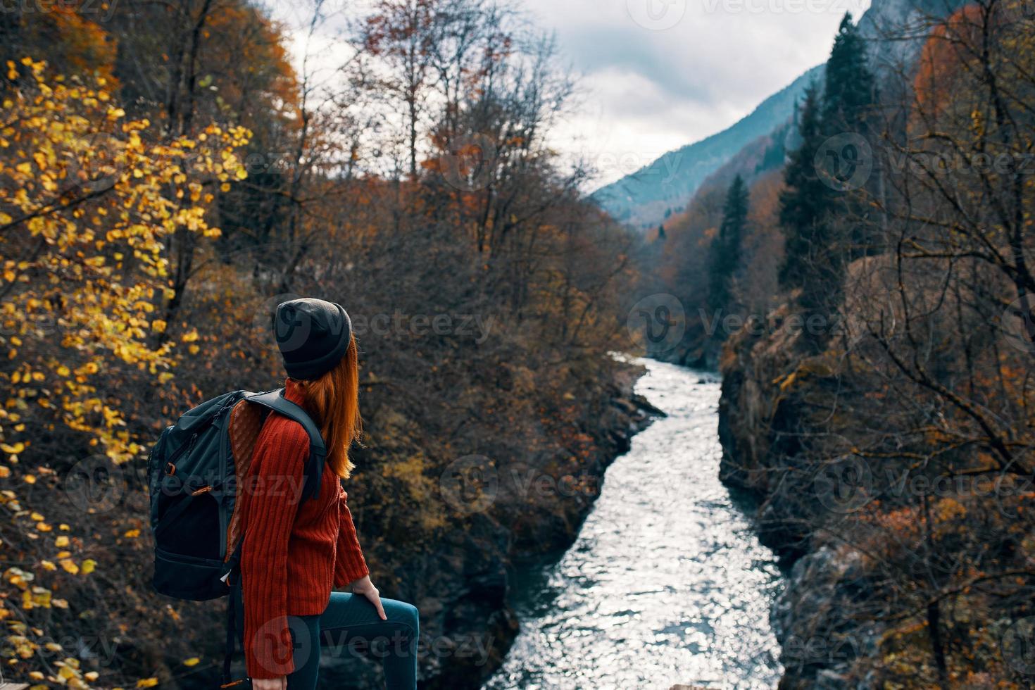 mulher caminhante com mochila dentro a montanhas outono floresta foto