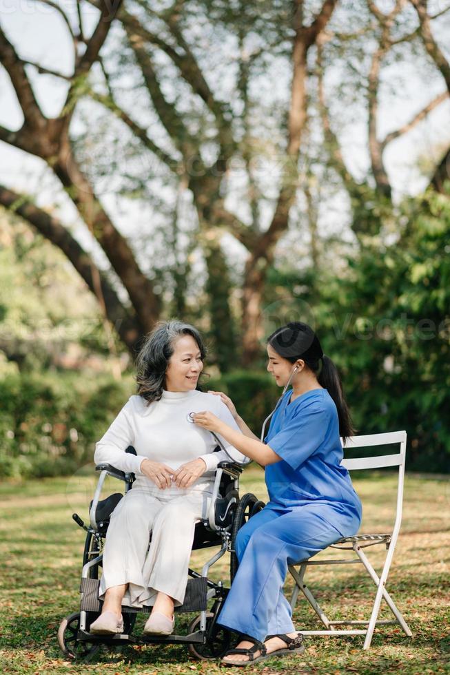 ásia fêmea mãos tocante velho fêmea mão ajudando mãos levar Cuidado do a idosos conceito dentro parque hospital foto