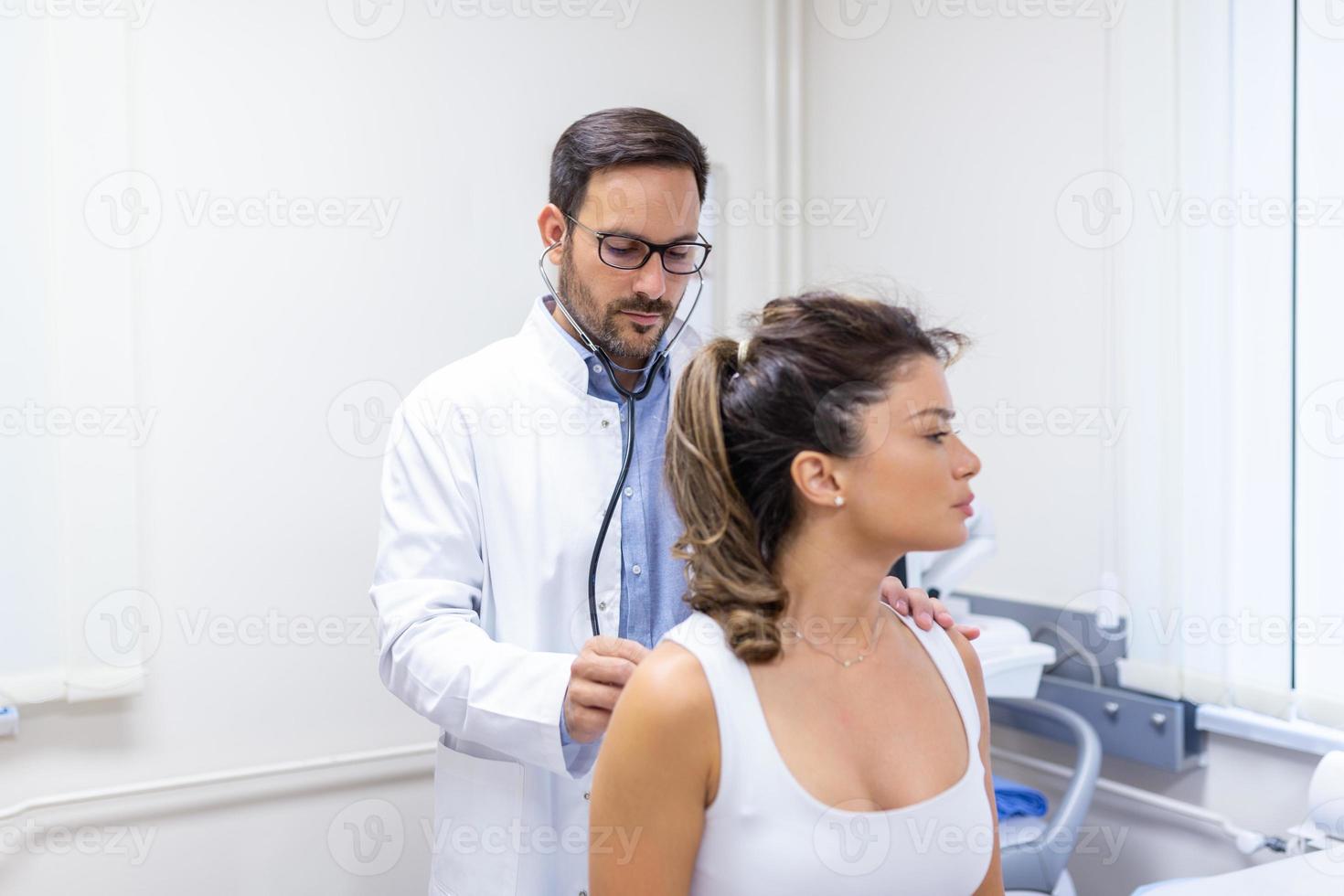 jovem fêmea paciente dentro a clínica sofrido a partir de pneumonia, ela é tosse a médico escuta para a respiração ofegante dentro a pulmões com uma estetoscópio. foto