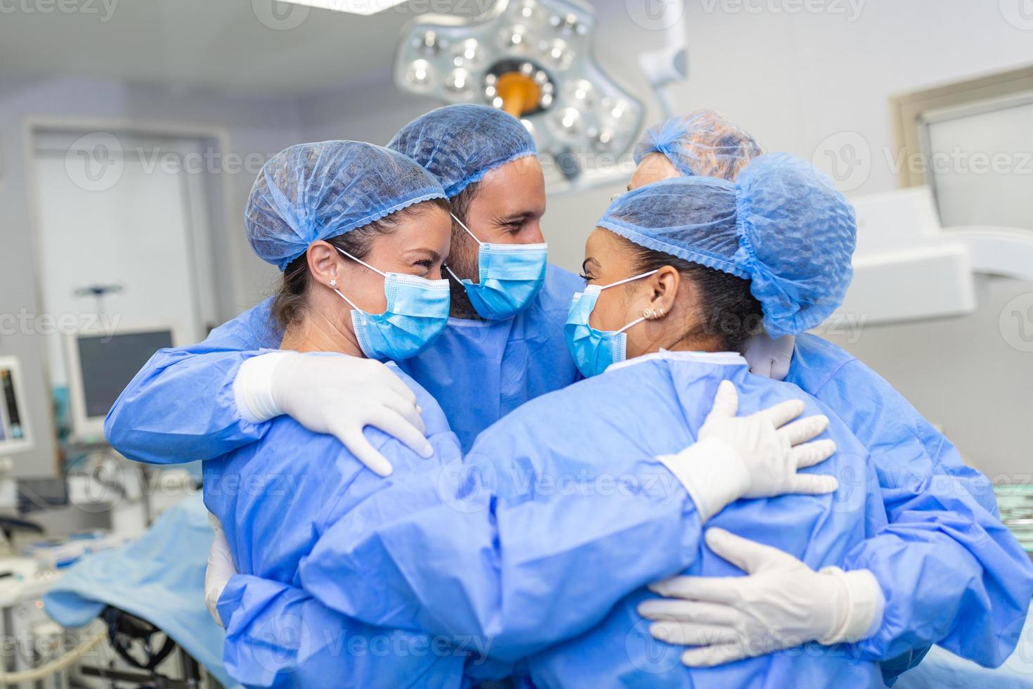 parcial Visão do trabalha duro masculino e fêmea hospital equipe dentro cheio protetora vestem em pé juntos dentro grupo abraço foto