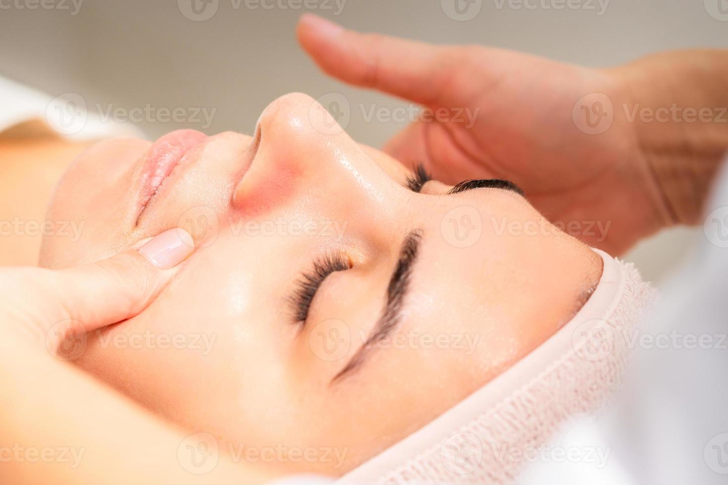 esteticista fazer linfático drenagem face massagem ou lifting facial massagem às a beleza salão. foto