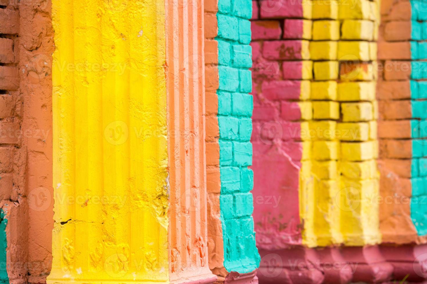 vermelho, laranja, amarelo e azul cor combinação velho texturizado danificar parede com colorida tijolos. foto