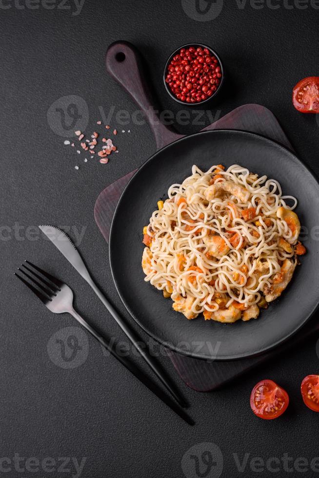 delicioso Macarrão com frango e legumes ou udon em uma Preto cerâmico prato foto