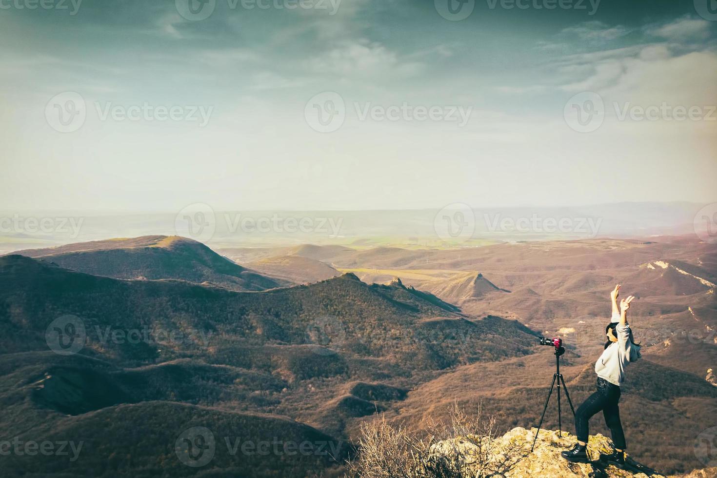 jovem mulher caucasiana feliz fotógrafo de viagens animado fotografando paisagem ao ar livre foto