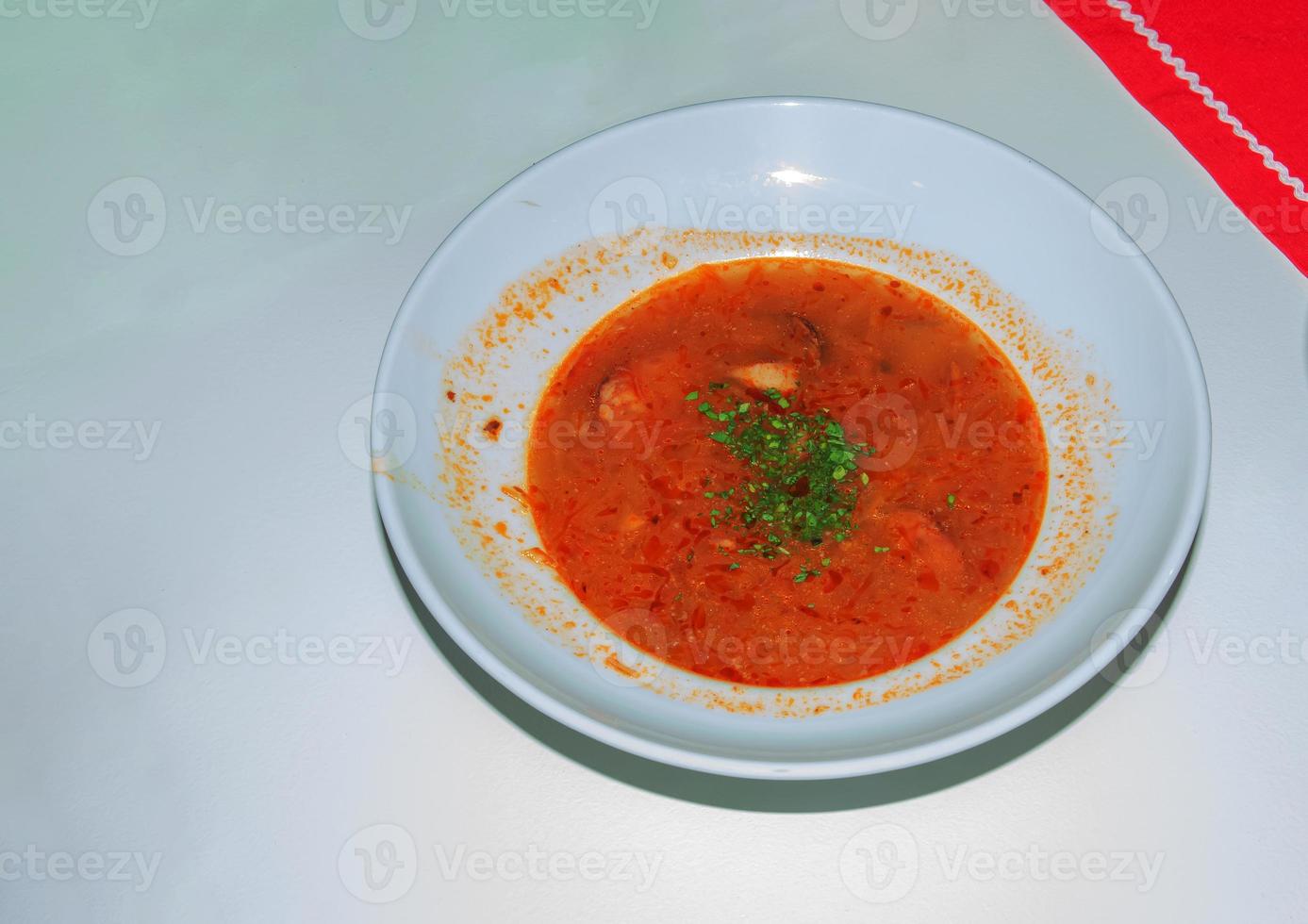 tigela do quente frango caldo com Macarrão em uma branco fundo. uma vidro do fresco espumoso cerveja. foto