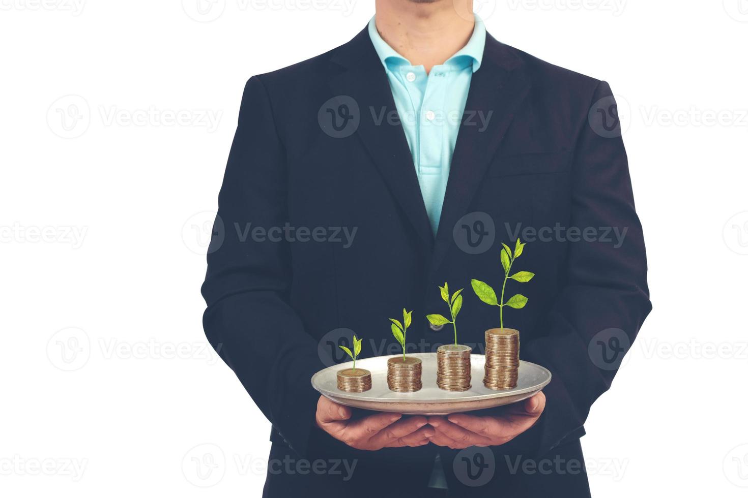 homem de negocios aguarde bandeja com plantas em moedas ,negócios brilho acima conceito. foto