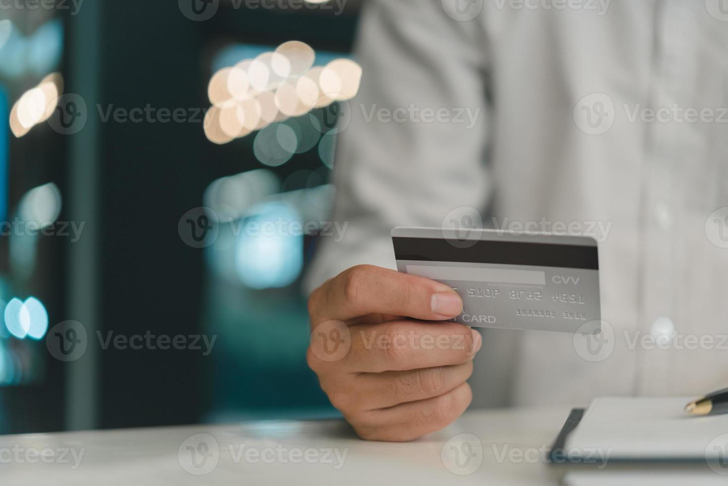 homem segurando crédito cartão compras on-line, finança Forma de pagamento comércio. foto