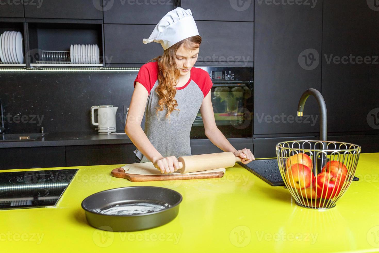 Adolescência menina preparando massa, assar caseiro feriado maçã torta dentro cozinha foto