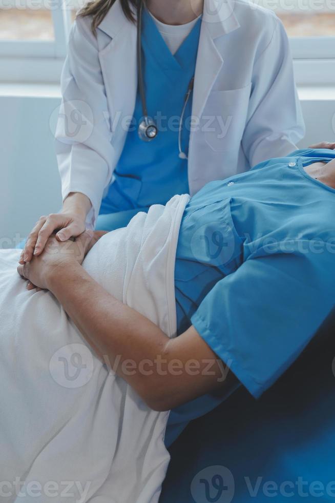 mulheres ásia médicos aguarde a paciente mão e encorajar e providenciar médico adendo enquanto verificação a paciente saúde dentro cama. conceito do Cuidado e compaixão, pré-natal Cuidado, ameaçado aborto foto