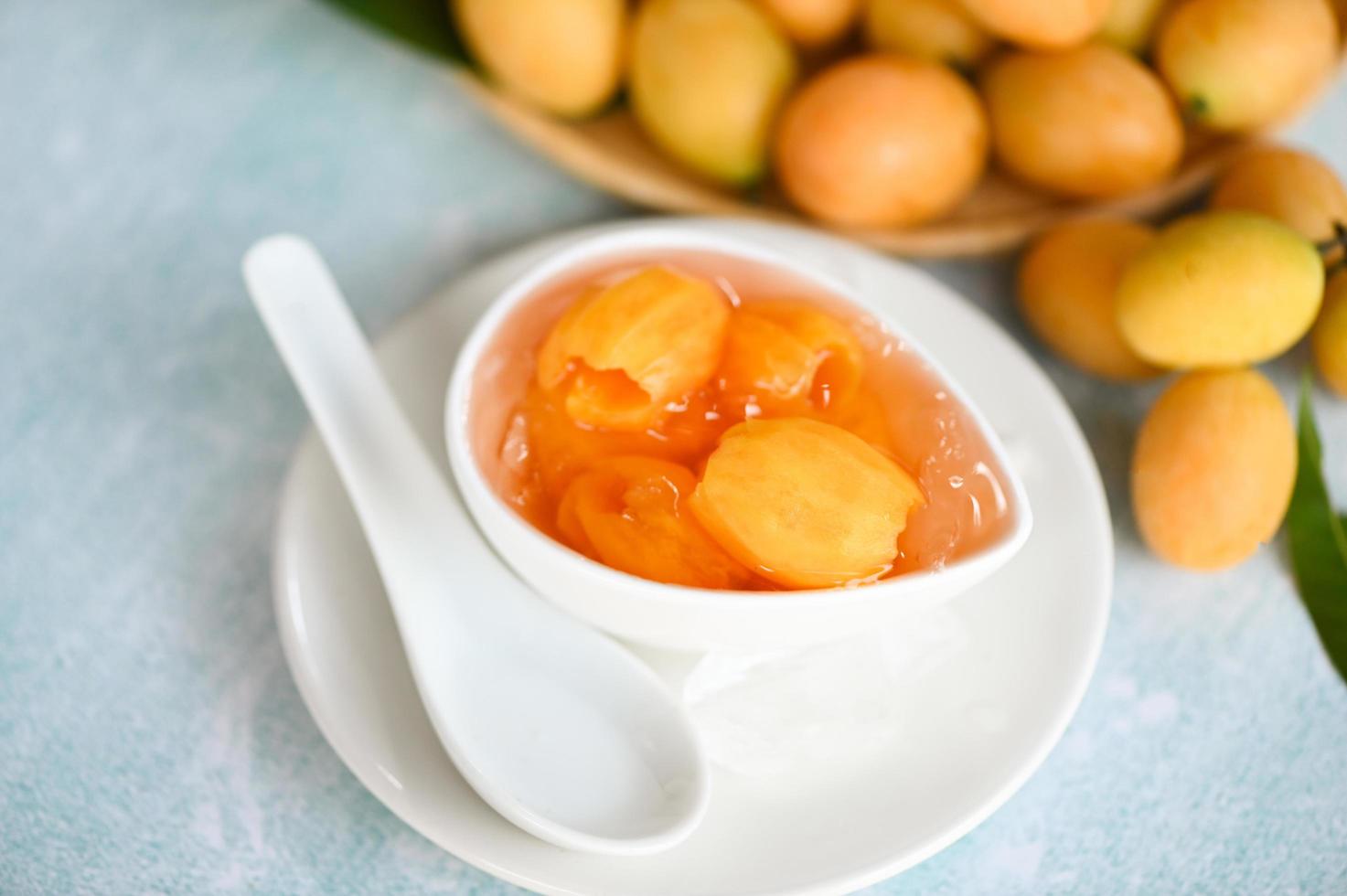 doce sobremesa mariana ameixa fruta em tigela para Comida e de madeira fundo, tropical fruta nome dentro Tailândia doce amarelo mariana ameixa maprang plango ou maionese criança foto