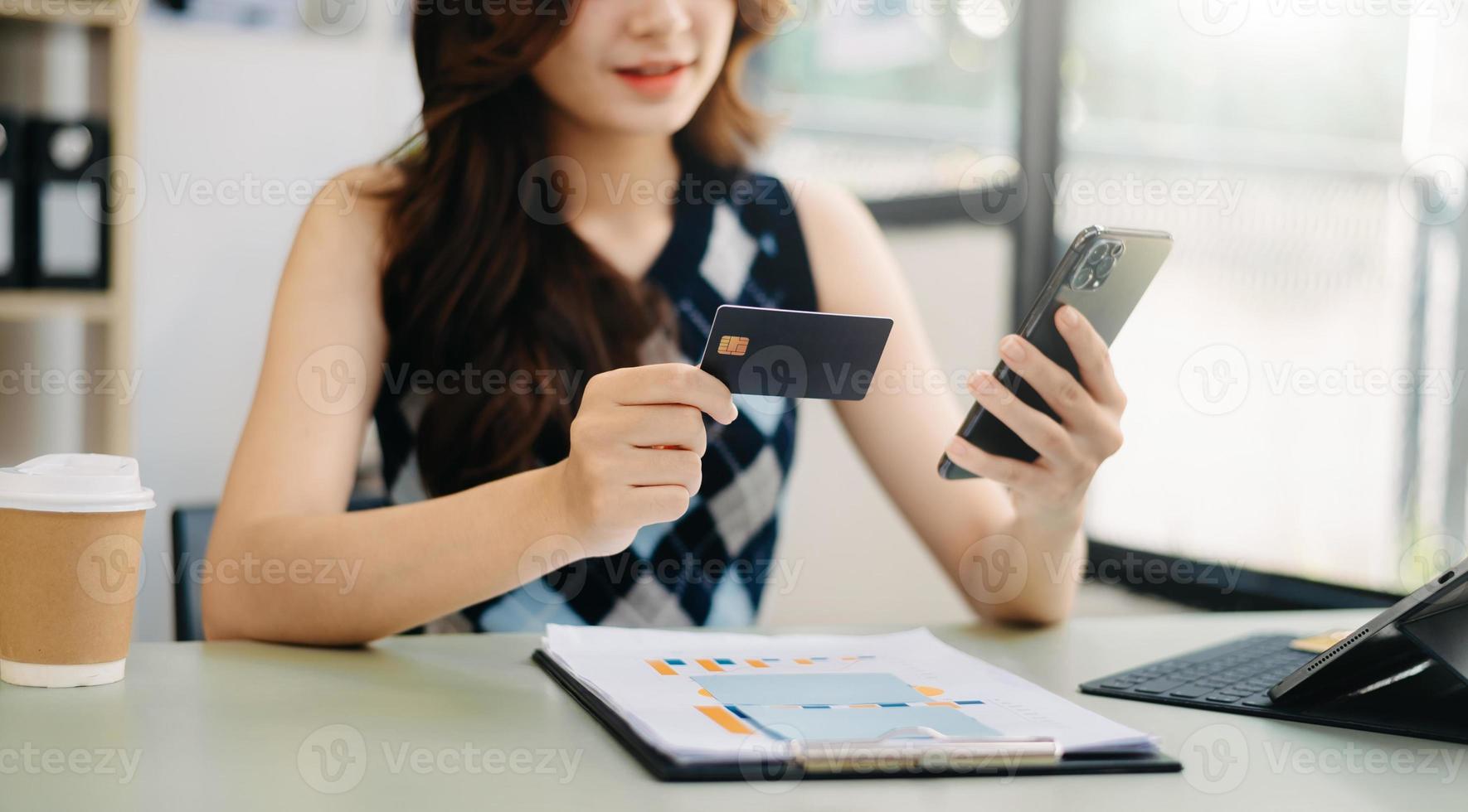 mãos de mulher de negócios usando smartphone e segurando cartão de crédito como compras online foto