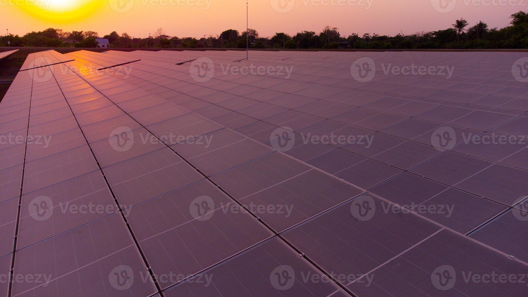 gerar limpar \ limpo energia com solar módulos dentro uma ampla parque campo dentro Ásia a partir de aéreo Visão de zangão durante pôr do sol. foto