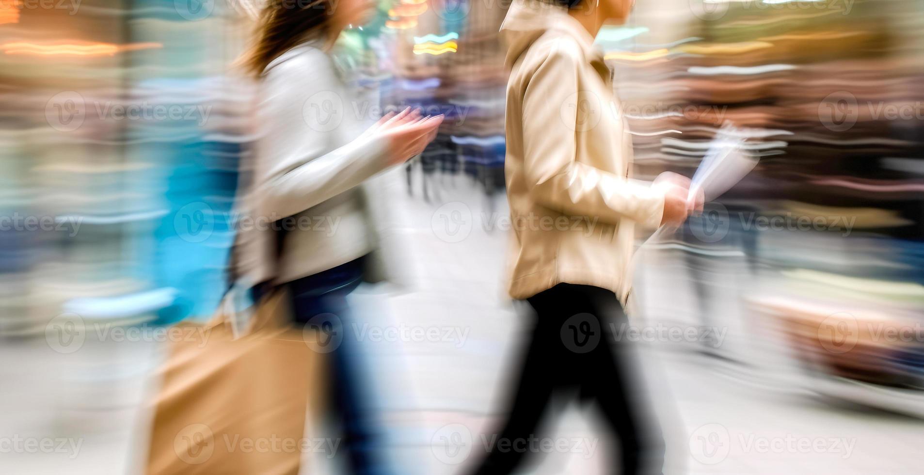 dois borrado dentro movimento mulheres com bolsas em cidade rua foto