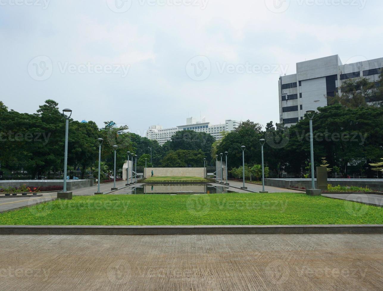 Visão do pessoas rega a jardim quintal. isto parque é cercado de vegetação e de várias jardim postes de iluminação foto