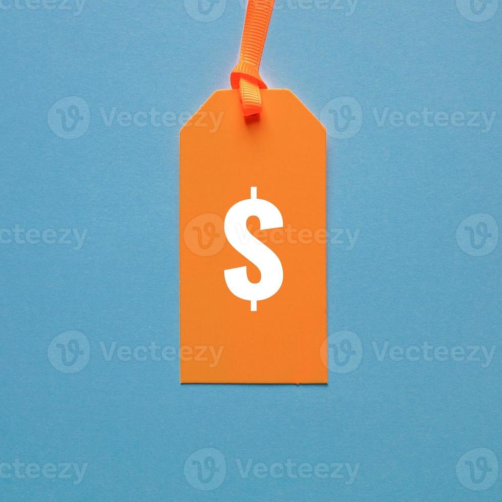 dólar símbolo dentro laranja preço tag em azul fundo foto