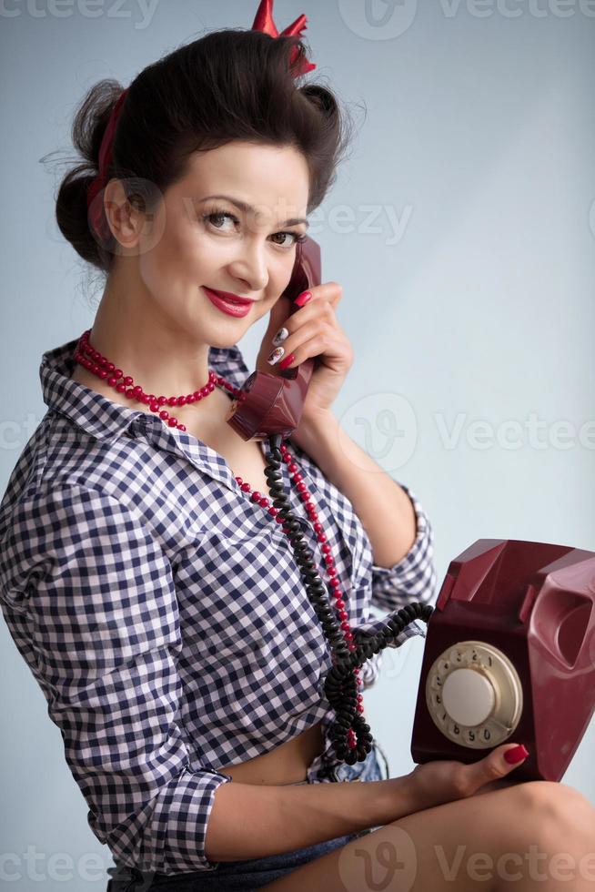 mulher dentro a estilo do a anos cinquenta. lindo retro menina falando em a velho Telefone. foto