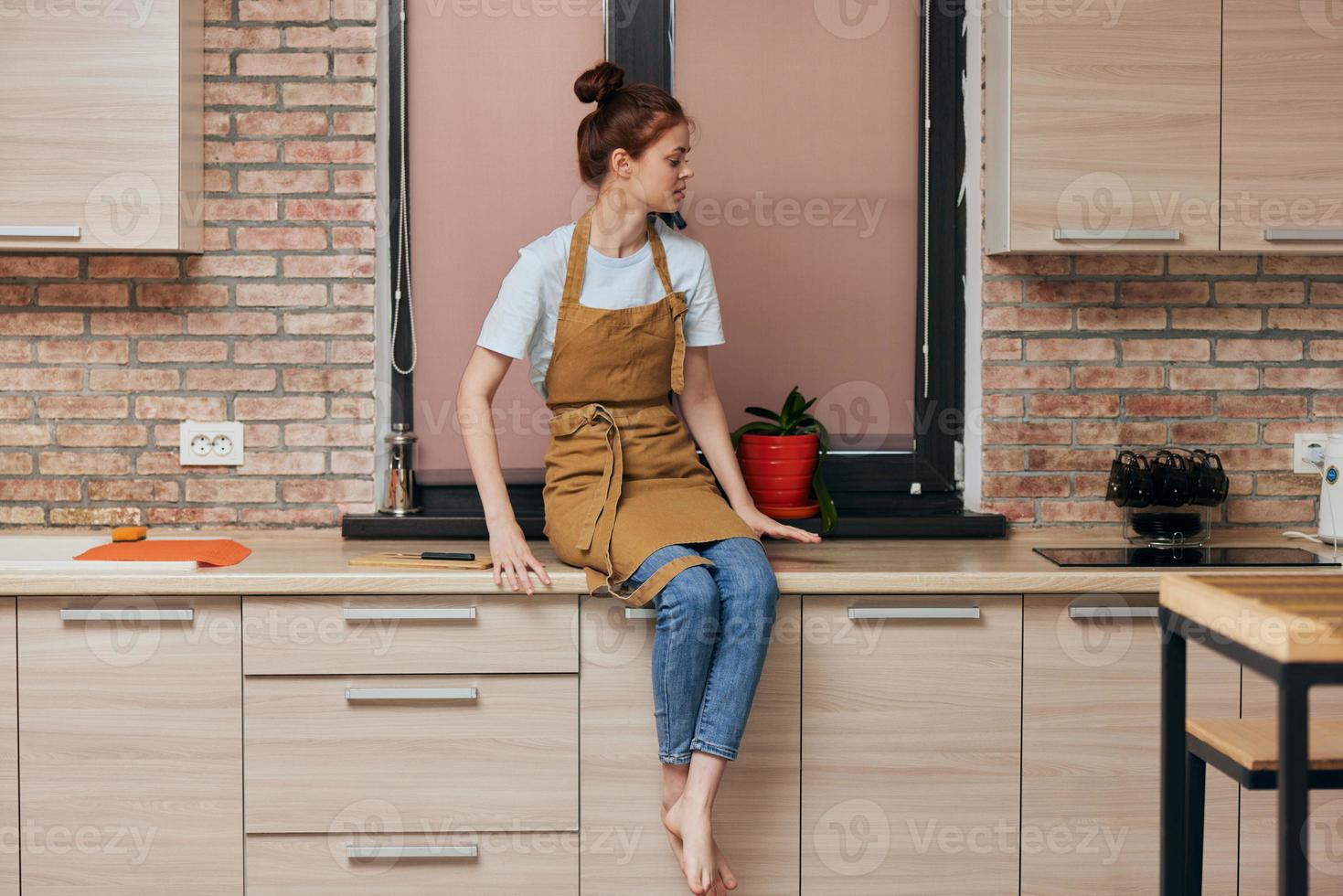 jovem morena mulher em cozinha contador foto