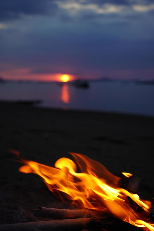 fogueira com pôr do sol em a de praia Como uma fundo. foto